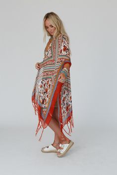 The lightweight Riviera Kimono is gorgeous in this bohemian print with artistic borders, vintage floral, and inviting colors. Inspired tassels adorn the angled knee - length hem, while side slits and wide sleeves give graceful flow to this one - size layer that adds style to every outfit. *Due to lighting and differences in monitors, actual colors may vary slightly from what appears online. Model is 5'8" and wearing a size One Size. Approximate measurements are as follows: ONE SIZE: Bust: 68", A Rust Lace Kimono, Bohemian Flowy Kaftan With Vibrant Print, Flowy Bohemian Kaftan With Vibrant Print, Bohemian Flowy Patterned Kaftan, Bohemian Kaftan With Floral Print And Kimono Sleeves, Bohemian Boho Print Kaftan For Beach Cover-up, Bohemian Kaftan With Boho Print For Beach Cover-up, Bohemian Kaftan With Boho Print And Kimono Sleeves, Bohemian Patterned Kaftan With Vibrant Print