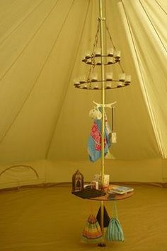 the inside of a large tent with several items on it and a lamp hanging from the ceiling