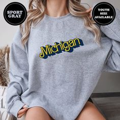 Michigan Football Sweatshirt, Michigan Football Shirt, Ann Arbor Michigan Sweatshirt, College Football Sweatshirt Show off your team spirit with our Michigan Football Sweatshirt, a must-have for any true Wolverines fan! This is not just another generic college sweater, but a unique piece that embodies the spirit of Michigan football and the U of M community. Crafted from premium quality cotton blend, this piece guarantees not only comfort but also durability. Available in a range of sizes from s College Crew Neck T-shirt With Letter Print, Crew Neck T-shirt With University Logo For Fall, Long Sleeve Cotton T-shirt With University Logo, Game Day Long Sleeve Tops With Team Logo, Sporty Tops With University Logo For Sports Events, Collegiate Crew T-shirt For Fan Gear, Game Day Sports Fan Crew Neck Top, Varsity Tops With Logo Print For Game Day, Sports Fan Crew Neck Top For Game Day