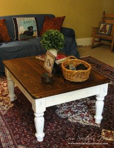 a living room with a couch, coffee table and rugs on the carpeted floor