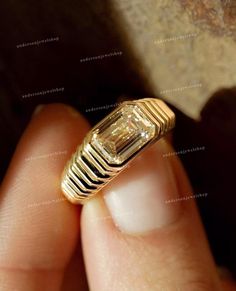 a gold ring with an emerald cut diamond