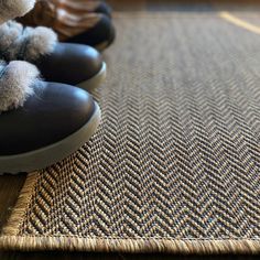 a pair of black shoes sitting on top of a rug