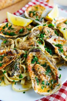 an image of a plate of food with clams and lemons on the side