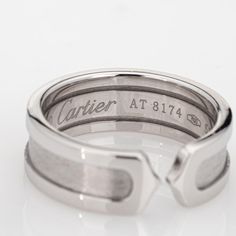 This is part of Chairish’s Fine Jewelry assortment.  Vintage Cartier Double C logo ring crafted in 18 karat white gold (circa 2000).    The out of production Cartier ring features a high polish outer bands with an inset satin finish. The ring is great worn alone or stacked with your fine jewelry from any era.  The ring is in very good condition and was recently lightly cleaned and polished. No box or papers.  Particulars:  Weight: 7.6 grams  Stones:  N/A  Size & Measurements: The ring is a size Luxury Sterling Silver Bands, Designer Platinum Rings For Formal Occasions, Engraved Cartier White Gold Jewelry, Timeless Cartier White Gold Ring, Luxury Silver Engraved Bands, Cartier Silver Rings Fine Jewelry, Timeless White Gold Cartier Ring, Cartier Silver Fine Jewelry Rings, Luxury Engraved Silver Bands