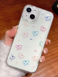 a person holding a clear case with colorful butterflies on the back and side of it