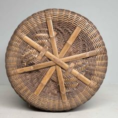 a wicker basket with five wooden sticks in it's center and four smaller ones at the bottom