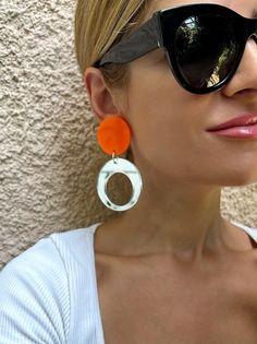 A Pair of Hoop Earrings that are made from Plexiglass and they open and close with Clip On. I used summer colors and the upper part is in orange color and the down hoop is made in a unique silver mirror color that smells summerThis pair is ideal for non pierced ears, they are comfortable and light.  Find them only at Chrstina Christi Store. MATERIALS - Plexiglass Parts. - Metal Parts. DIMENSIONS - Total length of Earrings: 9 cm (3.5') - Total width of Earrings: 3.5 cm (1.35') PROTECTION - Protec Modern White Clip-on Earrings, Trendy White Drop Clip-on Earrings, Trendy White Round Hoop Earrings, Trendy White Pierced Earrings, Trendy Clear Drop Earrings, Modern White Clip-on Earrings For Gift, Modern Orange Drop Earrings, Modern White Teardrop Hoop Earrings, Modern White Pierced Earrings