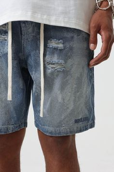 Bring an edgy touch to your casual wear with the Contrast Texture Ripped Denim Shorts. This pair is thoughtfully ripped throughout, adding a grungy twist to the classic washed blue color. With an elastic waistband design, which is highly unusual for denim shorts, you get the benefit of both style and comfort. The extended drawstrings allow for a customizable fit, adding to the unique appeal of these must-have shorts. Ripped throughout for a grungy aesthetic Classic washed blue color Elastic wais Casual Ripped Streetwear Bottoms, Spring Stonewashed Denim Bottoms, Urban Style Ripped Medium Wash Bottoms, Distressed Denim Blue Bottoms For Streetwear, Ripped Denim Jeans For Streetwear, Relaxed Fit Distressed Medium Wash Jean Shorts, Ripped Cotton Bottoms In Washed Blue, Distressed Medium Wash Jean Shorts, Relaxed Fit, Edgy Ripped Denim Jean Shorts