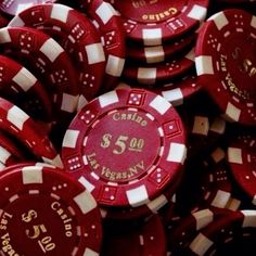 a pile of red and white poker chips with the number fifty on them in gold lettering