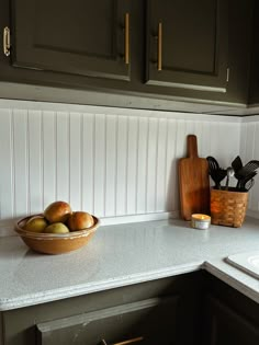 a bowl of fruit sitting on top of a kitchen counter