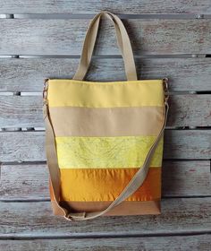 "This vibrant yellow canvas tote bag is the ideal accessory to carry in your free time, to work, to school or at any time of the day. Its sleek, modern trapezoid design and colourful yellow, beige and brown stripes will go perfectly with any casual summer or mid-season outfit. Its modern and elegant trapezoid design and its colourful yellow, beige and brown stripes combine perfectly with any casual outfit. It is a comfortable, durable and stylish bag. It allows you to carry everything you need, including your phone, wallet, cosmetics and much more. Materials: * Outside: Canvas, Cotton, Wild silk, Polyester upholstery * Lining:   Cotton satin (cotton/polyamide) * Padding: foam stabilizer, interfacing fabric * Strap: nylon * Zipper: nylon   Zipper puller: faux suede leather cord  * Gold meta Yellow School Shoulder Bag With Adjustable Strap, Yellow Shoulder Bag With Adjustable Strap For School, Yellow Cotton Shoulder Bag For School, Yellow Large Capacity Canvas Bag For Everyday Use, Yellow Large Capacity Satchel Canvas Bag, Trendy Yellow Canvas Bag With Adjustable Strap, Yellow Tote Shoulder Bag For School, Trendy Yellow Satchel Canvas Bag, Striped Tote Shoulder Bag For Travel