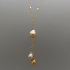 "These baroque shape Edison freshwater pearls have an amazing glow with metallic overtones. The pearls are large measuring 15 to 17 mm. The length of the necklace is 24\" and the pearls dangle 2 3/4\". The gold filled chain and gold plate sterling findings compliment the warm color of the pearls. Imperfections on the pearls add to their beauty and organic charm. This pink pearl Y necklace really makes a statement. It is an heirloom piece of jewelry that is timeless and elegant." Gold Baroque Pearl Charm Necklace, Gold Baroque Pearl Necklace With Pearl Charm, Gold Baroque Pearl Necklace, Gold Briolette Pearl Necklace, Gold Drop Baroque Pearl Necklace, Gold Baroque Pearl Drop Necklaces, Gold Baroque Pearl Drop Necklace, Gold Drop Necklace With Baroque Pearl Chain, Gold Baroque Pearl Necklace In Briolette Shape