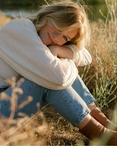 a woman sitting on the ground with her arms crossed