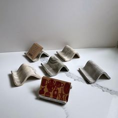 five pieces of metal sitting on top of a white counter next to a canister