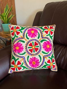 a decorative pillow on a brown leather chair