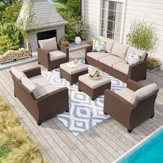 an outdoor living room with furniture and a pool in the backround next to it