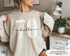 Step into your 70s in retro flair with our Hello 70 sweatshirt! This 70th birthday crewneck is a must-have for commemorating your Seventieth birthday in classic style. It also makes an ideal 70th birthday gift. ✨Please check the SIZE CHART image on the listing, and choose your size accordingly before placing your order.  🚫We do not accept exchanges, returns, or cancellations, however, if there are any print issues with the item please contact us right away. We'll be happy to make things right a Casual Birthday Sweatshirt With Lettering, Casual Sweatshirt With Lettering For Birthday, Hello 60, Hello Thirty, Hello 40, Twenty First Birthday, Sixtieth Birthday, 40th Birthday Shirts, Fifty Birthday