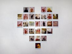 a white wall with many pictures arranged in the shape of a heart