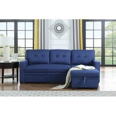 a living room with a blue couch and ottoman