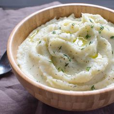 a wooden bowl filled with mashed potatoes on top of a table