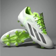 a pair of white and green soccer shoes