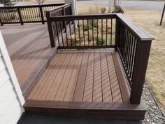 a wooden deck next to a white house