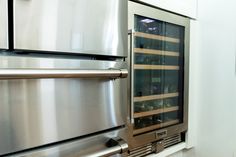 a stainless steel refrigerator with wine racks on the door