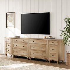 a large flat screen tv mounted to the side of a wooden dresser in a living room