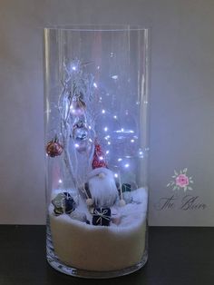 a glass vase filled with ornaments and lights