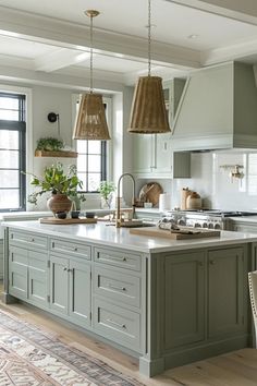 a large kitchen with an island in the middle and two hanging lights above it, along with potted plants