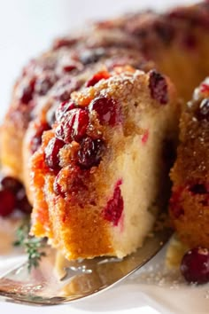 a close up of a cake on a plate with a fork in it and cranberry sauce