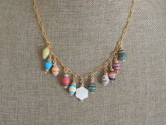 An 18kt gold plated paper clip chain holds an array of colorful paper beads that have been wire wrapped in the center hangs a flower shape mother of pearl charm. Wear this necklace alone or with others for a fun trendy look. Chain is 18kt gold plated brass and closes with an 18kt gold plated spring clasp. Links on the chain measure 6x2mm and charm sizes and styles will vary with each necklace. You will receive the necklace shown in the pics. With all jewelry please do not wear when running, showering or working out. Necklace length: 18inches Charms: Approx. 15-20mm To view other multi charm necklaces click here: www.etsy.com/shop/SoCalLux?section_id=28028076 To view my shop click here: www.etsy.com/shop/SoCalLux Paperclip Necklace, Necklace Trendy, Colorful Paper, Trombone, Paper Beads, Pearl Charms, Trendy Jewelry, Boho Necklace, Necklace Length