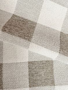 an upholstered checkered fabric with brown and white squares on the back ground