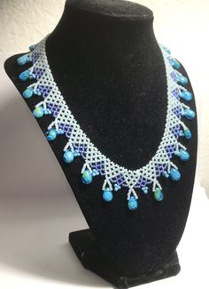 A handmade glass beaded necklace that is perfect for any occasion: parties, holidays, birthdays, anniversaries. All products are hand-crafted by my mother. Dimensions: - Actual Length: 22.5 cm - Collar Length: 13.0 cm - Width: 14.0 cm - Height: 2.0 cm Lightweight, high quality with a beaded hook as a clasp. Will respond to concerns and suggestions promptly. Acrylic Crystals: 1.2 cm. Shipping costs: Free Domestic Shipping. All orders are sent by air-mail with tracking number. Time of delivery: Es Turquoise Beaded Glass Jewelry, Handmade Adjustable White Turquoise Necklace, Artisan Teardrop Beaded Necklace, Turquoise Necklace With Large Beads As Gift, Turquoise Jewelry With Large Beads For Gift, Gift Turquoise Jewelry With Large Beads, Handmade Czech Glass Beaded Necklaces With Oval Beads, Handmade Teardrop Beaded Necklace, Handmade Turquoise Crystal Necklace With Adjustable Fit