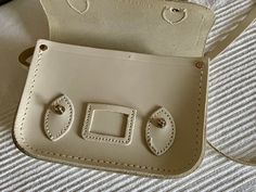 "It is a pre owned The Cambridge Satchel Company bag and shows signs of wear. The exterior does come with light scuffing at the edges and some surface scratches from normal used, no major flaws. The inside looks very clean and undamaged. The hardware is functional. This bag is in very good overall used condition. Bag length 6.5\" Bag height 5\" Bag depth 2\" Strap drop 26\"max. FREE DOMESTIC SHIPPING Please view the photos to evaluate the condition. Any questions regarding an item, ask prior to Small Vintage Bag For Everyday Use, Vintage Cream Leather Shoulder Bag, Vintage Beige Bag With Leather Lining, Vintage Beige Shoulder Bag With Leather Lining, Vintage Cream Shoulder Bag For Everyday, Cream Vintage Shoulder Bag For Everyday Use, Classic Beige Satchel With Leather Lining, Vintage White Shoulder Satchel, Vintage Cream Satchel For Travel