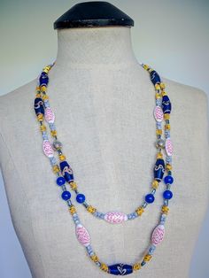 This sophisticated, chic necklace features vintage 13x26mm African Blue Feathered Francies glass beads and striking 27mm white acrylic beads with red etchings as focal points. Accented with 6mm stacked brushed gold copper wavy potato chip disks, 6x4mm Czech glass blue terracotta pellets, 4x7mm dark blue faceted glass rectangles framed by 4mm bumpy golden rondelles, 10mm Kyanite Jade, and 12mm pocked silver beads with golden caps, this necklace combines a rich variety of textures and colors.  The Blue Terracotta, Necklace African, Oxidized Brass, Double Strand Necklace, Chic Necklace, Red Necklace, Blue Feather, Focal Points, Hammered Gold