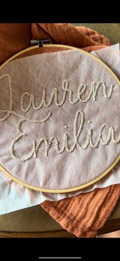 the embroidery is on top of an orange towel and it says lauren emelion