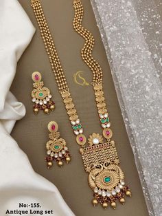 Description :- Necklace With Earrings | Temple Jewelry Set | Gold Jewelry Set |Bridal Jewelry Set | Choker Set | Necklace Set | Peacock Jewelry Set Gift yourself a royal look with this perfectly crafted kundan necklace set from Manalisstudio. Crafted with high quality kundan stones and pearls, it is impressive in design. The green enamel artwork adds perfect texture to the design. Perfect for weddings and festivities, this antique necklace set should be put on with your favorite sari or lehenga. White Peacock Design Jewelry For Celebration, Fusion Style Peacock Design Necklace For Wedding, Gold Bridal Necklace With Peacock Design For Reception, Festival Reception Kundan Necklace With Peacock Design, White Wedding Jewelry With Peacock Design, Peacock Design Jewelry Sets For Wedding, Kundan Necklace With Peacock Design For Wedding And Festivals, Peacock Design Jewelry Sets For Wedding And Diwali, Round Temple Necklace With Peacock Design For Weddings