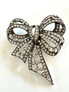 Joan Rivers jewelry antique silver-tone filagree brooch embellished with Austrian crystals. Excellent condition. Very pretty brooch to use on lapels, hats, scarfs and neckline of dresses just for a few suggestions. Thank you for looking and shopping with Betty Jo! Questions? We are happy to help. Please look at all our other designer and vintage pieces here: https://www.etsy.com/shop/BettyJosBoutique Joan Rivers Jewelry, Bow Brooch, Wedding Brooch, Jewelry Antique, Joan Rivers, Vintage Pieces, Austrian Crystal, Scarfs, Antique Jewelry