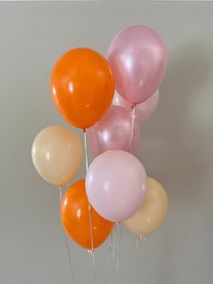 a bunch of balloons that are on top of each other in front of a wall