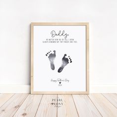 a baby's hand and foot print in a wooden frame