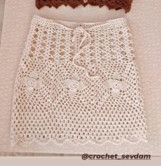 two crocheted skirts are sitting next to each other on a white tablecloth