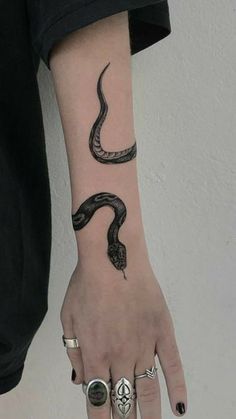 a woman's hand with a snake tattoo on it