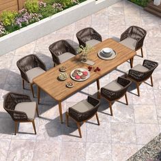 an outdoor dining table with chairs and plates on the outside patio, next to a potted plant