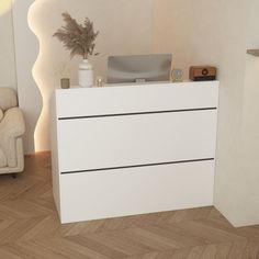 a white dresser sitting in the corner of a room