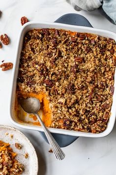 a casserole dish filled with sweet potato casserole and topped with pecans