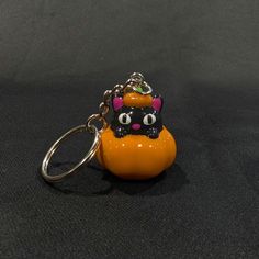 an orange keychain with a black cat on it