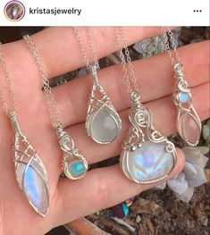 a person is holding three different necklaces in their hand, one with an opalite and the other with a rainbow stone