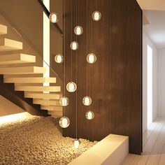 a room with some lights hanging from the ceiling next to a stair case and stone floor