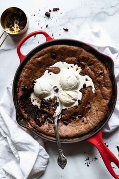 a skillet with ice cream and chocolate cake in it next to a bag of doughnut chips